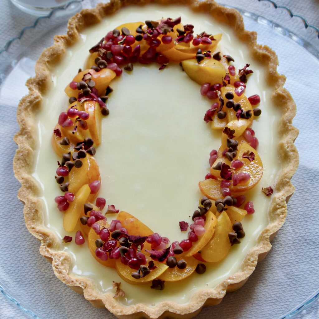 Crostata con panna cotta alla vaniglia, susine, melograno e gocce di cioccolato